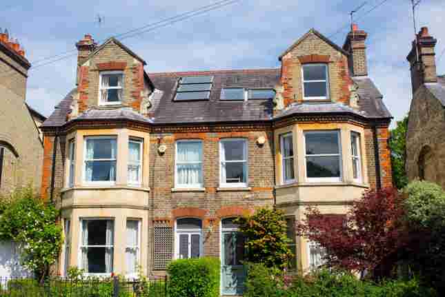 A row of Victorian semi-detached houses with bay windows and dormer roofs
